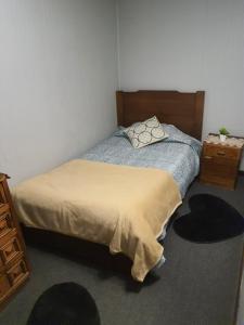 a small bedroom with a bed and a dresser at Cabañas casa blanca in Laraquete