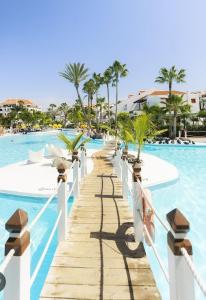 a boardwalk leading to the pool at a resort at il centro delle vacanze in Playa de las Americas