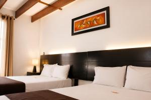 a hotel room with two beds and a picture on the wall at Deville Inn in Lima +66 photos