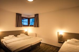 um quarto com 2 camas e uma janela em Residence Lipno em Lipno nad Vltavou