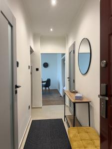 a hallway with a mirror and a table at Radnóti Apartman Győr in Győr