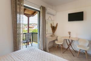 a bedroom with a bed and a desk and a table at Tsimiklis Apartments in Finikounta