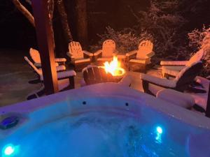 a hot tub with a fire in a yard at night at Windswept Vistas in Boone