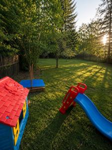 a playground with a plastic slide in a yard at Wellspace Forest Retreat in Karlovy Vary