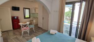 a small room with a table and a kitchen with a view at Ragousis Apartments in Parikia