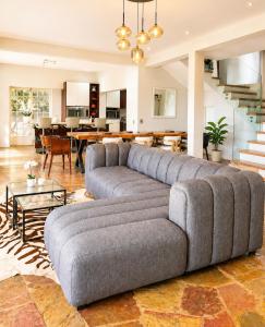 a living room with a gray couch and a dining room at Ekhaya in Hartbeespoort