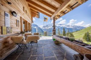 a building with sheep chairs and a view of mountains at Tällihütte in Gadmen