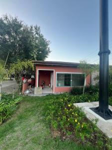 a house with a porch and a person sitting in front of it at Hotel Betel Rio Bonito in Estaçao Realengo