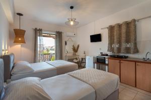 a hotel room with two beds and a kitchen at Tsimiklis Apartments in Finikounta