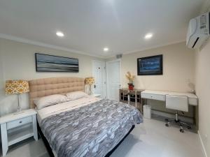 a bedroom with a bed and a desk and a computer at Sunset Beach Paradise Home in Sunset Beach