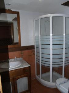a bathroom with a glass shower and a sink at Hotel Rural El Rocal in Ledesma