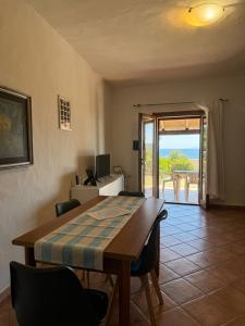 a dining room with a table and chairs and a patio at Appartamenti Cala d'Ambra in San Teodoro