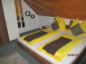 a bedroom with a large bed with yellow sheets and pillows at Ferienwohnung Steinwender in Döbriach