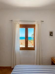 a bedroom with a window with a view of the ocean at Appartamenti Cala d'Ambra in San Teodoro