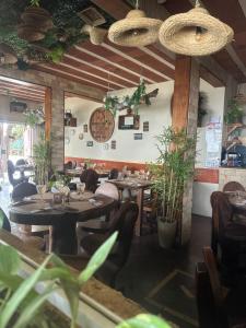 a dining room with tables and chairs and plants at Pousada Berro do Bode in Cabaceiras