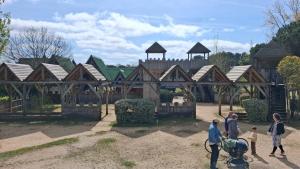 a group of people standing in front of a playground at Parc résidentiel Les Moussaillons in Hourtin