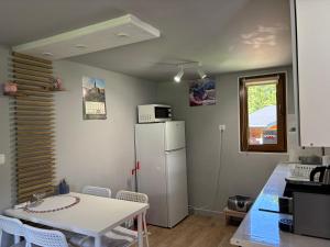 a kitchen with a table and a white refrigerator at Lawendowa Weranda in Krasnobród +6 photos