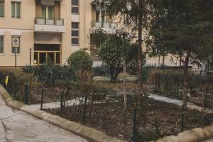 a garden with trees in front of a building at Free WiFi Netflix Settefontane Elegant Suite in Trieste