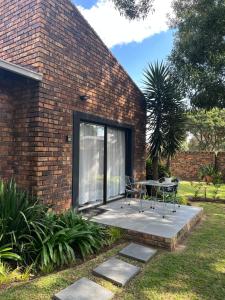 a brick house with a patio with a table at Dragonfly in Boksburg +2 photos