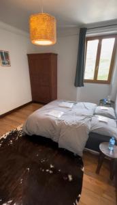 a bedroom with a bed and a table and a window at Beau Refuge du Galibier in Le Monêtier-les-Bains