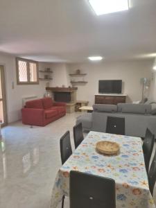 a living room with a table and a couch at La taverna del puntone in Puntone di Scarlino