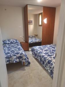 a bedroom with two beds with blue and white sheets at La taverna del puntone in Puntone di Scarlino +2 photos