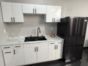 a kitchen with a sink and a refrigerator at TinyHouseMX2 Comodidad, lujo y playa que se disfruta in Barre De Navidad
