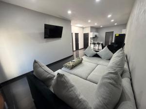 a living room with a white couch and a television at TinyHouseMX2 Comodidad, lujo y playa que se disfruta in Barre De Navidad