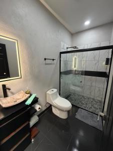 a bathroom with a toilet and a glass shower at TinyHouseMX2 Comodidad, lujo y playa que se disfruta in Barre De Navidad +14 photos