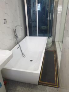 a white bath tub in a bathroom with a shower at Sbk3apartments in Ologode +25 photos