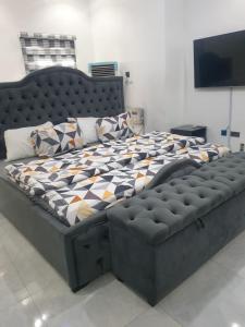 a large bed in a bedroom with a black frame at Sbk3apartments in Ologode