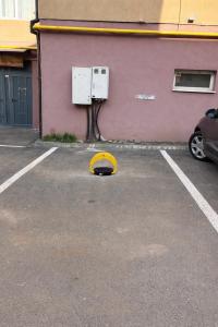 a yellow object in a parking lot next to a building at Yellow Apartment in Floreşti