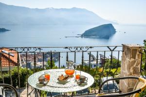 a table with a glass of orange juice on a balcony at Studios Kalina in Budva