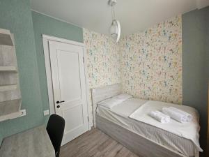 a small bedroom with a small bed with flowers on the wall at BST Batumi Leo in Angisa