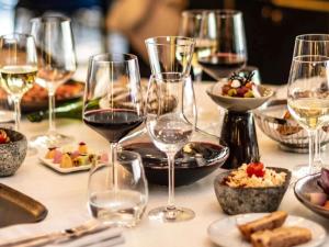 a table topped with glasses of wine and plates of food at Sofitel Lisbon Liberdade in Lisbon