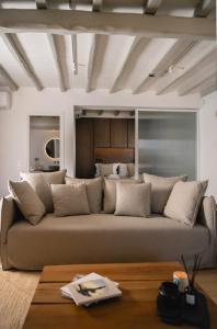 a living room with a large couch in front of a bed at Villa AELIA by LLB Mykonos - 2BDR - Sea & Sunset view in Mikonos