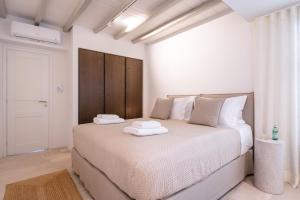 a bedroom with a bed with two towels on it at Villa AELIA by LLB Mykonos - 2BDR - Sea & Sunset view in Mikonos