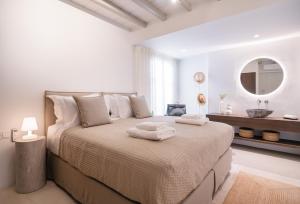a white bedroom with a large bed with towels on it at Villa AELIA by LLB Mykonos - 2BDR - Sea & Sunset view in Mikonos +68 photos