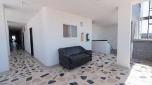 a black chair sitting in a room with a wall at Damar Hotel Collection Valledupar in Valledupar