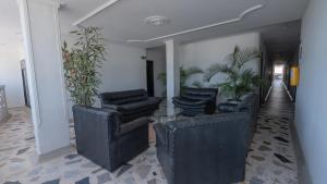 a lobby with chairs and a table and plants at Damar Hotel Collection Valledupar in Valledupar