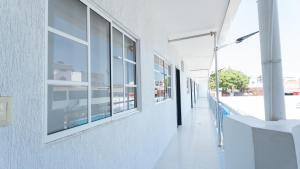 a hallway of a white building with windows and a street at Damar Hotel Collection Valledupar in Valledupar