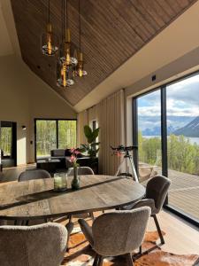 a dining room with a table and chairs with a view at LyNora - A private fjord retreat in Indre Ravelseidet