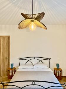 a bedroom with a large bed and a chandelier at Tenuta Piccioni Relais,Pool and Spa in Colonnella