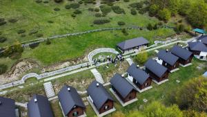 a group of people walking around a row of houses at Katun Komovi in Andrijevica
