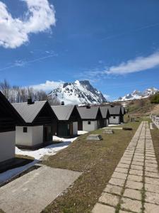 a row of buildings with a mountain in the background at Katun Komovi in Andrijevica