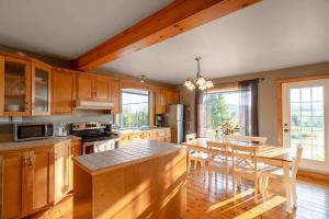 a kitchen with wooden cabinets and a table with chairs at Rustic Chalet Hideaway - Hot Tub & Trail Access in Saint-Léonard-de-Portneuf