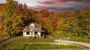 a small house in the middle of a field at Rustic Chalet Hideaway - Hot Tub & Trail Access in Saint-Léonard-de-Portneuf
