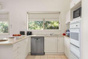 a white kitchen with a sink and a dishwasher at Harbour Creek in Ulladulla