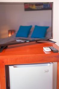 - une télévision sur la table en bois avec télécommande dans l'établissement Hotel Los Corales, à West End