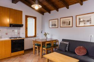 a kitchen and a living room with a couch and a table at Villa Sanziana in Menaggio